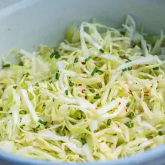Frischer spitzkohl salat mit Schnittlauch und Chili-Flocken, appetitlich in einer Schüssel angerichtet.