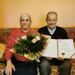 Para Genowefa i Jan Dziedzic świętuje 70 rocznicę ślubu. Otrzymują gratulacje i bukiet kwiatów.