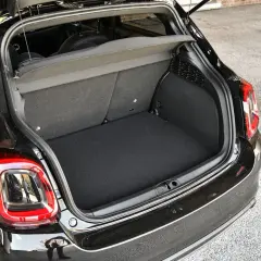 Coffre ouvert d'une Fiat 500X noire, prêt à accueillir vos bagages pour une escapade.