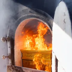 Złota trumna płonie w piecu kremacyjnym, a płomienie tańczą wokół. Czy kości się palą? To pytanie towarzyszy tej scenie.
