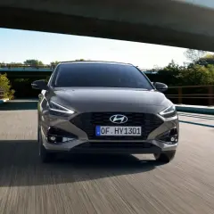 Szary Hyundai i30 GD jedzie po moście wśród zieleni.