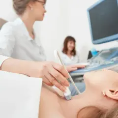 Ecografia tiroidea: un medico valuta la salute della paziente, un'indagine che può influenzare quanto guadagna un endocrinologo.