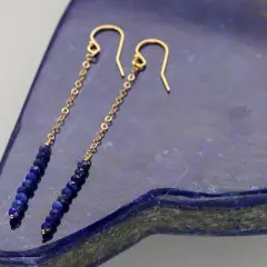 Eleganckie kolczyki z lapis lazuli na złotym łańcuszku, zakończone wygodnym zapięciem bigiel.