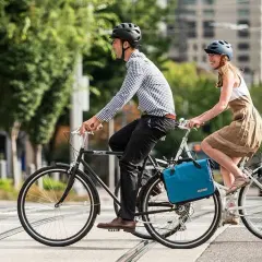 Ein Paar radelt mit Gepäcktaschen durch die Stadt. Perfekt für eine ADFC Fahrradtour, die Liste der Ausrüstung ist komplett.