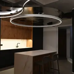 Moderna cocina con isla central y una lámpara colgante transparente que ilumina el espacio.