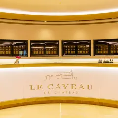 Le caveau Guigal, un comptoir moderne avec des bouteilles de vin exposées dans des vitrines lumineuses.