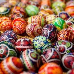 Bunte, kunstvoll bemalte Ostereier liegen dicht beieinander. Was ist an Ostersonntag passiert? Ein Fest der Farben und Traditionen!