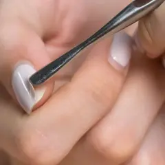 Manicure con attrezzo per cuticole, un passo fondamentale per imparare come fare le unghie in gel a casa e ottenere un risultato professionale.
