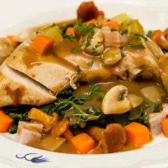 Pyszny kurczak supreme w sosie, z pieczarkami, marchewką, ziemniakami i zielonymi warzywami.