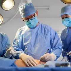 Chirurdzy w maseczkach i fartuchach operują. Czas jest kluczowy, gdy trzeba szybko operować raka.