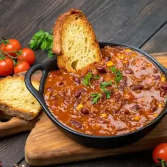 Gęste chili con carne z fasolą i kukurydzą, podane z chrupiącym pieczywem. Idealny obiad na dwa dni, który rozgrzeje i nasyci.