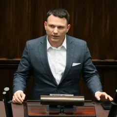 Sławomir Mentzen w garniturze przemawia, zastanawiając się, czy Sławomir Mentzen wykorzystuje AI do pisania swoich postów w kampanii prezydenckiej.