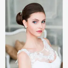 Panna młoda z eleganckim upięciem i biżuterią, w białej sukni.