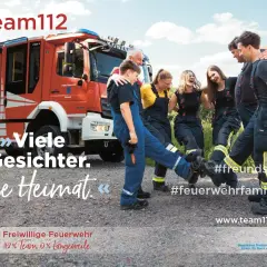 Feuerwehr mitgliederwerbung ideen: Eine Gruppe lacht und tanzt vor einem Feuerwehrauto. Sie zeigen, dass die Feuerwehr eine #feuerwehrfamilie ist.