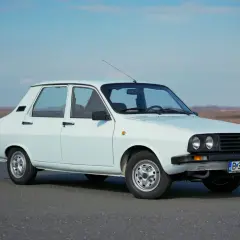 Biała Dacia 1300 na tle nieba i pól. Klasyk rumuńskiej motoryzacji gotowy na podróż.