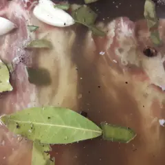 Mięso do pieczenia w zalewie z liśćmi laurowymi i czosnkiem. Peklowanie mięsa do pieczenia to klucz do soczystości.