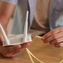 Ręce podłączają kabel do routera, próbując rozwiązać problem **netia brak internetu**.