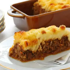 Une part de hachis parmentier dorée, avec sa couche de purée de pommes de terre texturée, prête à être dégustée.