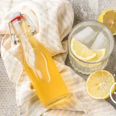 Erfrischender Zitronensirup im Glas mit Eis und Zitronenscheiben. Ein tolles Rezept für selbstgemachten Zitronensirup.
