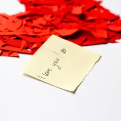 Kawałki czerwonego serca i karteczka z napisem "I love you!". To dowód, że kocham Cię w każdym języku.