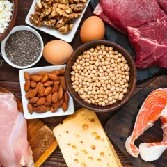 Assortiment d'aliments riches en protéines : bœuf, poulet, saumon, œufs, fromage, amandes, pois chiches, haricots, noix et graines de chia. Un concentré d'aliment fer pour la vitalité.