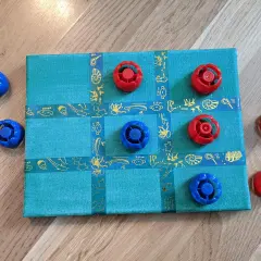 Selbstgemachtes Spielbrett mit blauen und roten Spielfiguren. Ein tolles Bastelprojekt für Kinder!