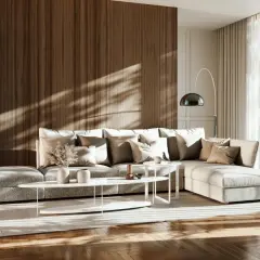 Przytulny salon w stylu japandi z dużą, szarą sofą, drewnianą ścianą i roślinami.