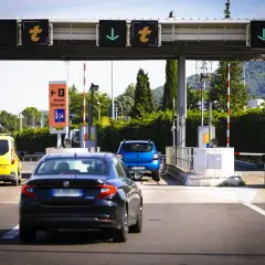 Voitures attendant au péage de l'autoroute A49. Panneaux lumineux indiquant les voies.