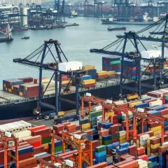 Terminal przeładunkowy Poczty Polskiej, gdzie paczka czeka na transport. Kontenery i dźwigi w porcie.