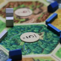 Fragment planszy do gry strategicznej, z niebieskimi domkami i szarymi elementami.