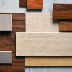 Campione di diversi tipi di parquet in varie tonalità di legno, dal chiaro al scuro, con venature visibili.
