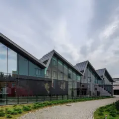Nowoczesna architektura muzeum sztuki współczesnej w Krakowie Mocak z wielkoformatowymi portretami na szkle.