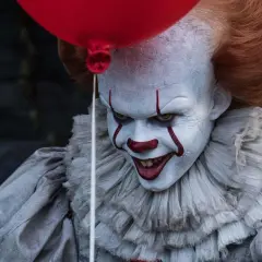 Przerażający klaun Pennywise, znany ze slasherów, trzyma czerwony balon.
