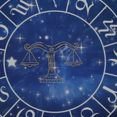 Zodiakalny krąg z wagą pośrodku i symbolami znaków powietrznych na tle gwieździstego nieba.