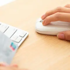 Dłoń trzyma kartę płatniczą przy klawiaturze, gotowa do transakcji online. Może to być początek procesu chargeback Santander.