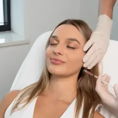 Kobieta poddawana zabiegowi z użyciem strzykawki, część kuracji anti aging.