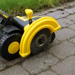 Żółta elektryczna zamiatarka do kostki z czarnymi kołami i szczotką, gotowa do pracy na podjeździe.