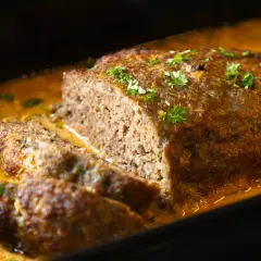 Saftiger Hackbraten mit cremiger Soße, garniert mit Petersilie. Ein köstliches Hackbraten Rezept für die ganze Familie.