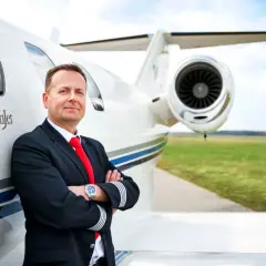 Pilot w mundurze przy CitationJet. Marzysz, jak zostać pilotem samolotu pasażerskiego? To zdjęcie może być inspiracją.