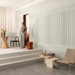 Elegancka kobieta w stylowym wnętrzu z drewnianą lamperią i nowoczesnymi meblami.