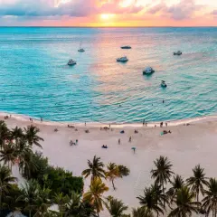 Piękna plaża z palmami i łodziami na turkusowym morzu. Idealne miejsce, by zastanowić się, kiedy lecieć do Cancun.