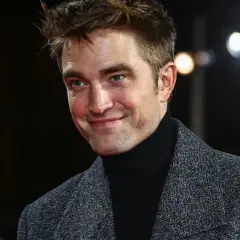 Robert Pattinson z uśmiechem, jakby wspominał swoje **dziecko**ństwo.