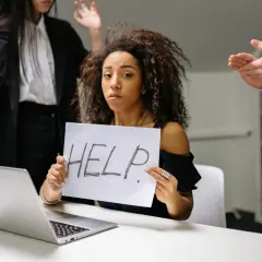 Kobieta z kartką "HELP" szuka sposobu, jak pozbyć się chwilówek. Wokół niej widać zaniepokojonych ludzi.