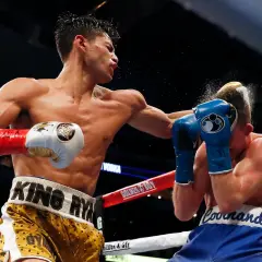Boxer lands a powerful left hook, sending a spray of sweat and water into the air. This is how to throw a left hook with maximum impact.