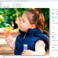 Dziewczynka puszcza bańki. Program Easy Photo Unblur pokazuje, jak wyostrzyć zdjęcie, regulując suwaki wygładzania i szczegółowości.