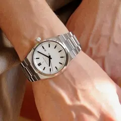 Elegancki zegarek na metalowej bransolecie na męskim nadgarstku. Klasyczny design, na której ręce nosi się zegarek, podkreśla styl.