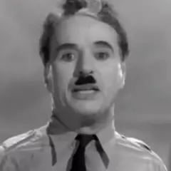Charlie Chaplin, con baffi e camicia, ricorda il suo discorso in "Il grande dittatore", un film che gli valse un Oscar onorario.