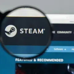 Lupa powiększająca logo Steam i napis "STEAM" na ekranie komputera.