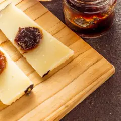 Fette di formaggio con miele e marmellata su tagliere. Perfetto per capire quanto può stare il formaggio fuori dal frigo.