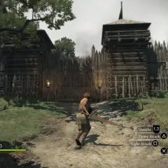 Postać w grze Dragon's Dogma 1 zbliża się do drewnianej bramy warownej.